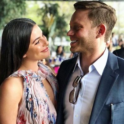 Both Lea Michele and Zandy Reich are smiling looking at each other.